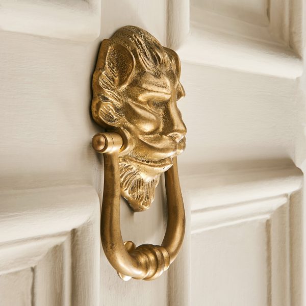 large lions head door knocker aged brass