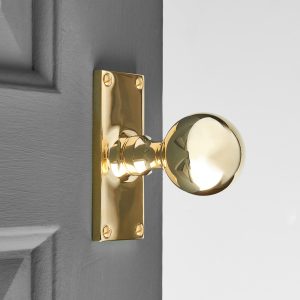 round door knobs on rectangular backplate (pair) polished brass