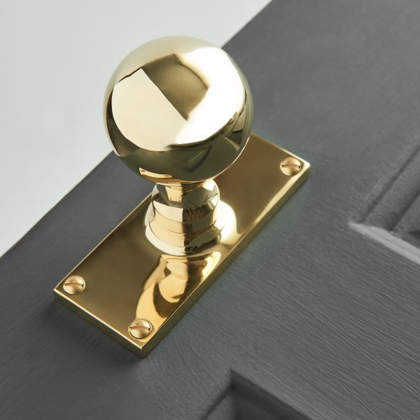 round door knobs on rectangular backplate (pair) polished brass